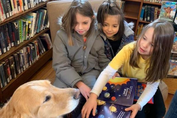 Kids and dog at library reading books