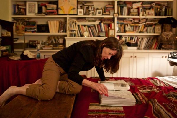 Joanne O'Connor with books in living room