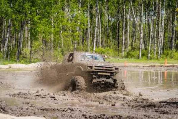 Pick-up truck driving through mud bog