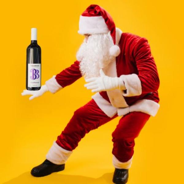 Santa holding a bottle of Three Brothers Wine